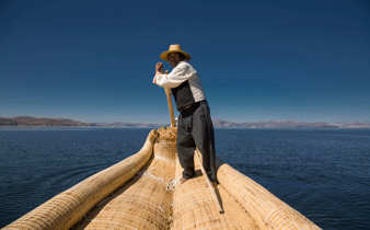 Traditional reed boat glides across Peru's Lake Titicaca in the Andean highlands. 
