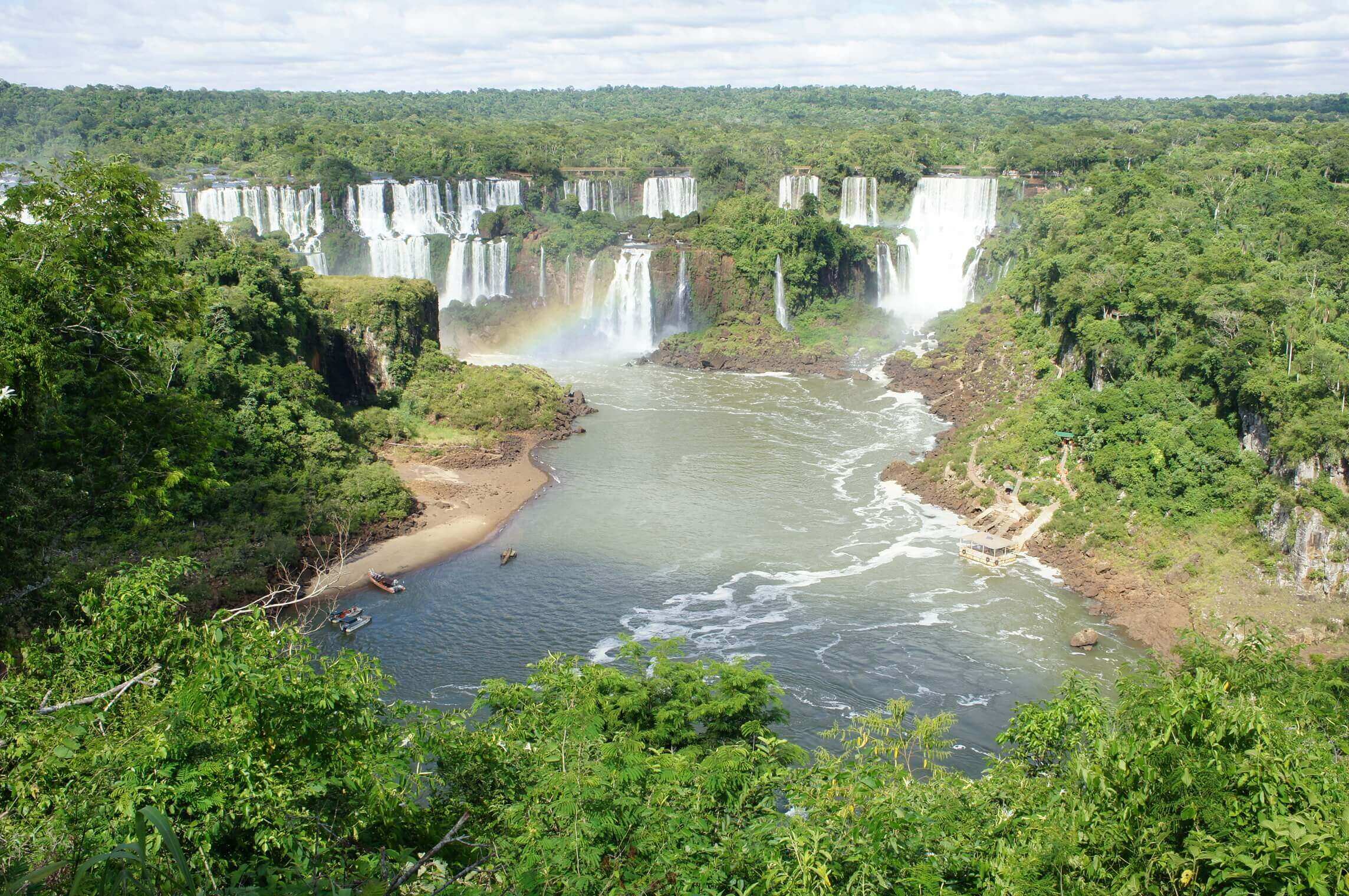 Iguassu Falls thunders through Brazil's rainforest in a sweeping panoramic view. 